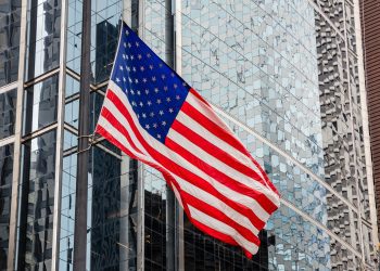 American flag in Chicago, Illinois downtown. Glass facade buildings background.