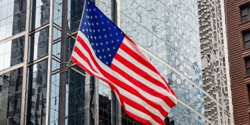 American flag in Chicago, Illinois downtown. Glass facade buildings background.