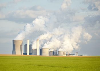 Green Fields In Front Of Industry Skyline