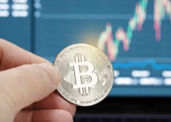 Hand holding a bitcoin coin