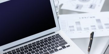 Laptop and business charts on desk