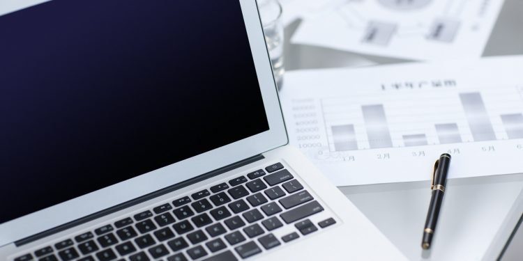 Laptop and business charts on desk